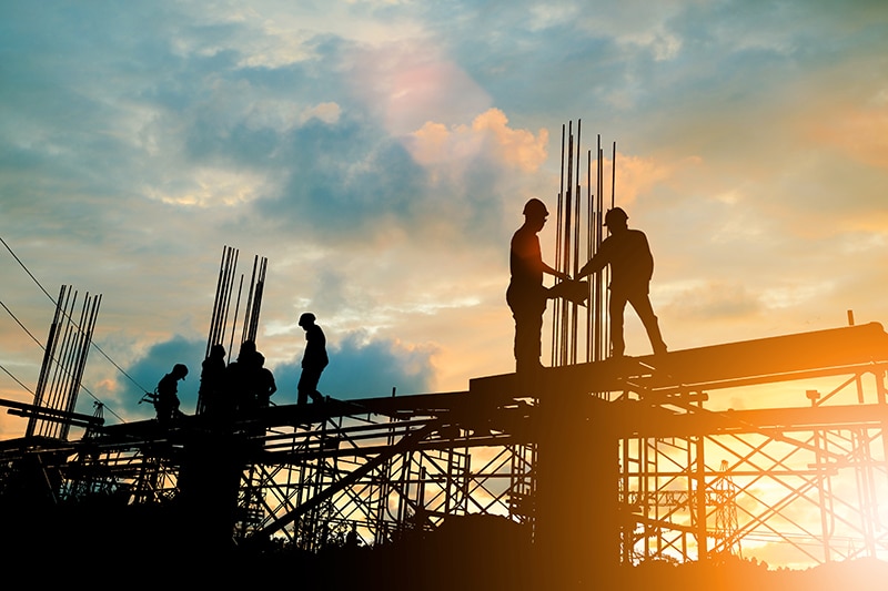 Silhouette of engineer and construction team working at site over blurred background sunset pastel for industry background with Light fair.Create from multiple reference images together.