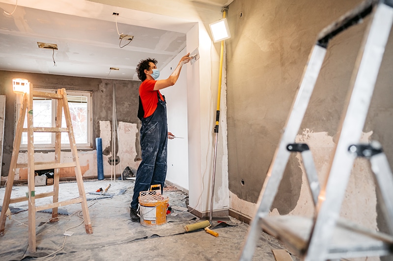 Construction worker plastering and smoothing concrete wall